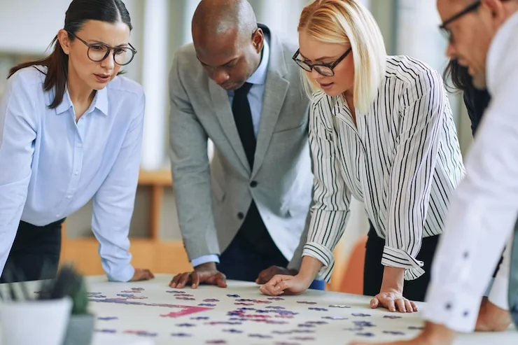 A group leaning over a table covered in planning notes