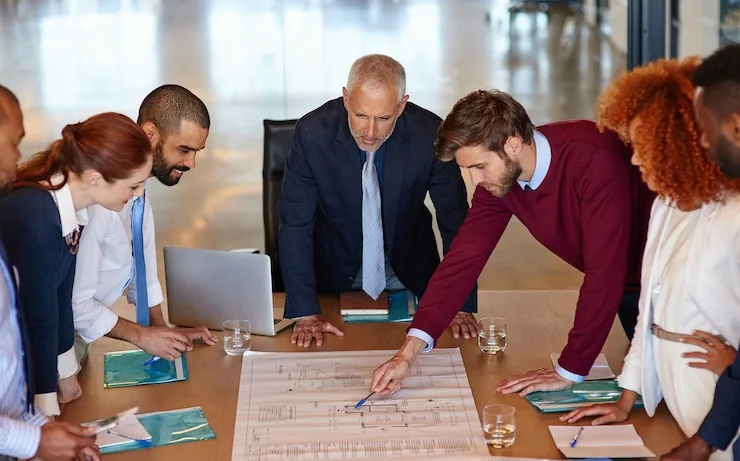 A group working through printed charts spread across a table