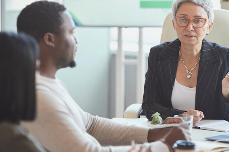 An older woman speaking during a meeting with colleagues